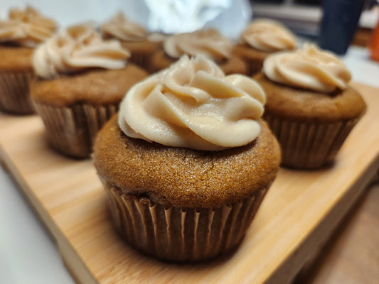Gluten-free Pumpkin Muffins with cinnamon cream cheese frosting on a wooden board
